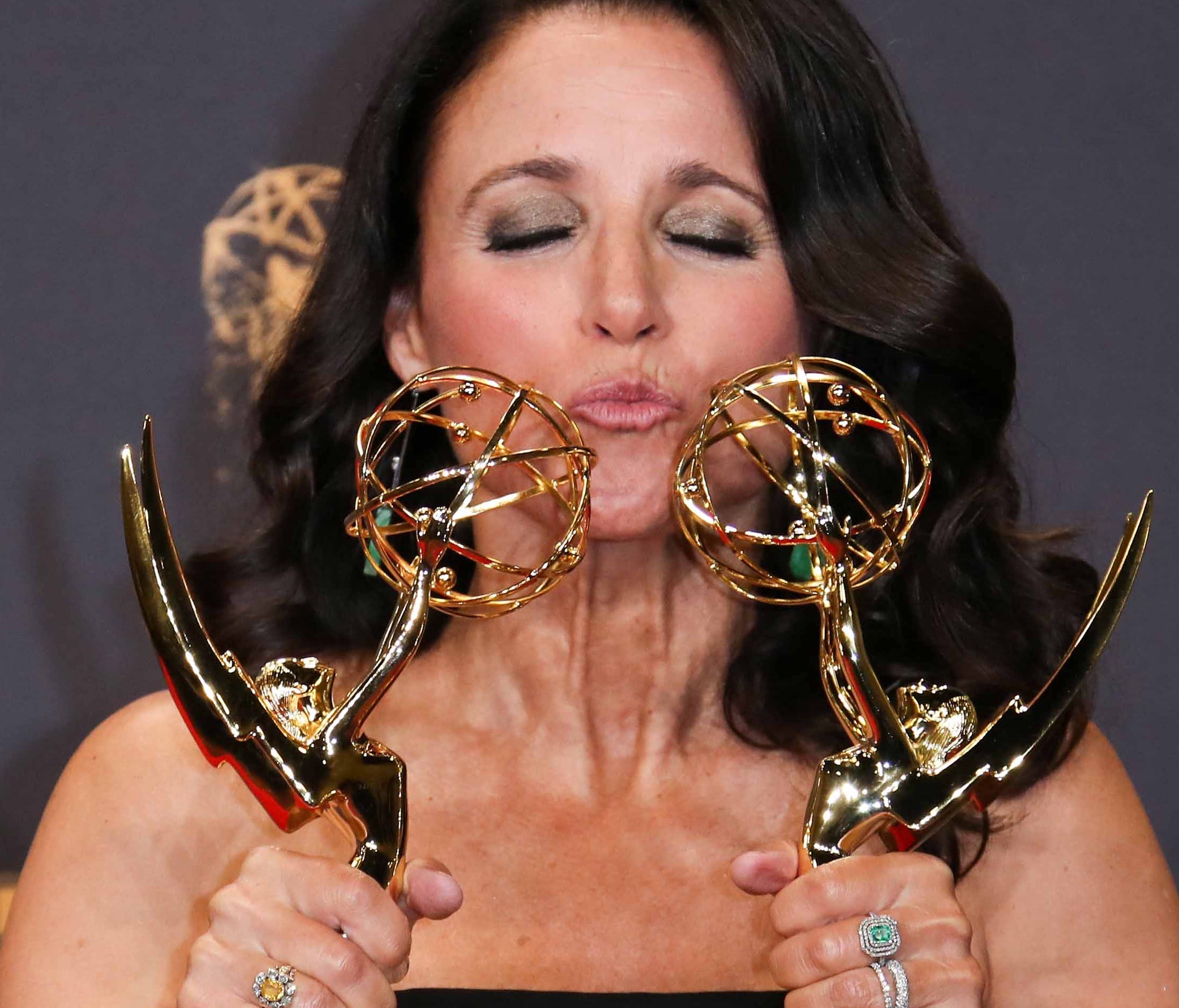 Julia Louis-Dreyfus  smooches her awards for outstanding actress and best comedy series in the Emmys trophy room.