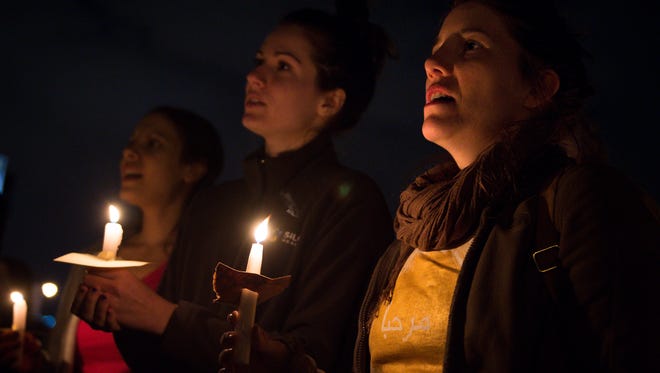 Sara Denson, right, of Nashville, holds a candle during a vigil and rally for immigrants and refugees at the Coleman Park Community Center in Nashville on Feb. 1, 2017.