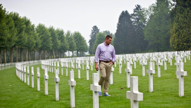 In this Wednesday May 23, 2018 photo, United States Marine Corps Reserve Captain Owen Gardner Finnegan walks among the headstones at the Aisne Marne cemetery in Belleau, France. The World War I battle of Belleau Wood in northern France pitted untested U.S. forces against the more-experienced Germans, who were making a push toward Paris. It became a defining moment, proving the Americans’ military mettle and helping turn the tide of the war. (AP Photo/Virginia Mayo)