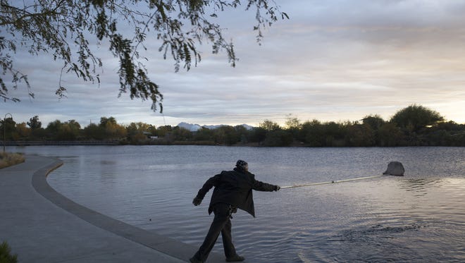 Robert Guerrero cleans debris from a pond at the Riparian Perserve at Water Ranch in Gilbert.