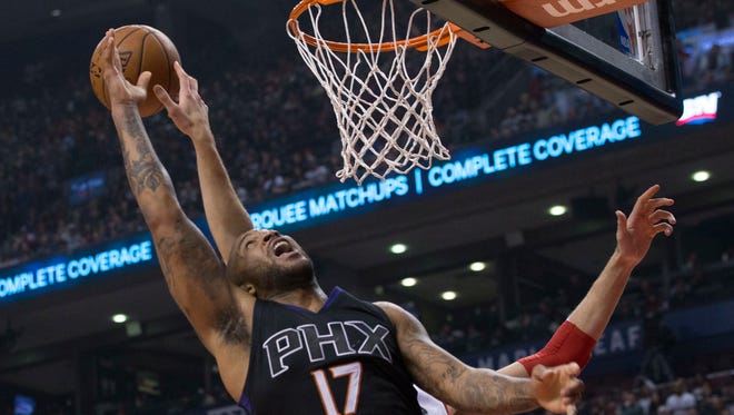 Phoenix Suns' P.J. Tucker (17) jumps for a rebound with Toronto Raptors' Jonas Valanciunas during first half NBA basketball action in Toronto on Sunday, Jan. 22, 2017.