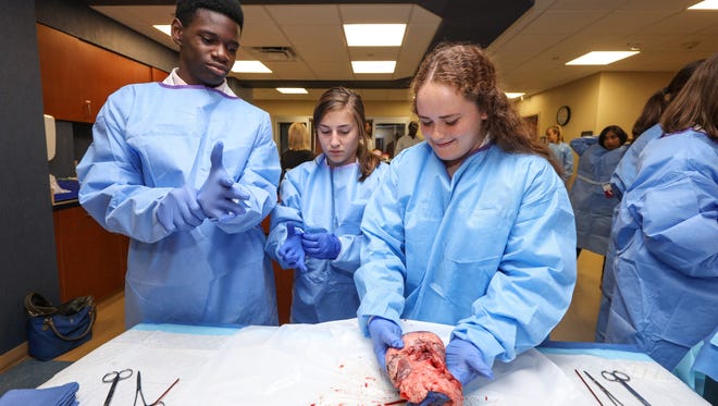 Jaylon Braxton (far left) preparing to dissect the pig heart.