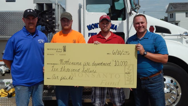 The Montezuma Volunteer Fire Department is presented a check for $10,000 by representatives of the Monsanto Fund. Pictured, from left, are: Montezuma Volunteer Fire Department Chief, JR Shearer; Brandon Sutfin, volunteer firefighter and Monsanto seed technician; Brian Wilson, volunteer firefighter and Monsanto seed technician; and Scott Metz, production lead, Monsanto Grinnell.
