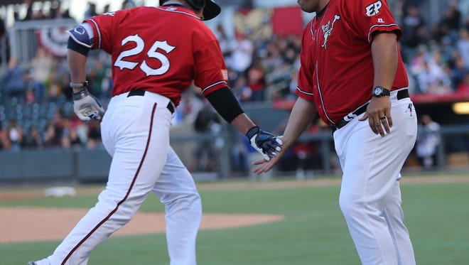 El Paso manager Rod Barajas congratulates Hunter Renfroe as Renfroe rounds third base after clubbing a home run during the team's game against the San Diego Padres on March 31.