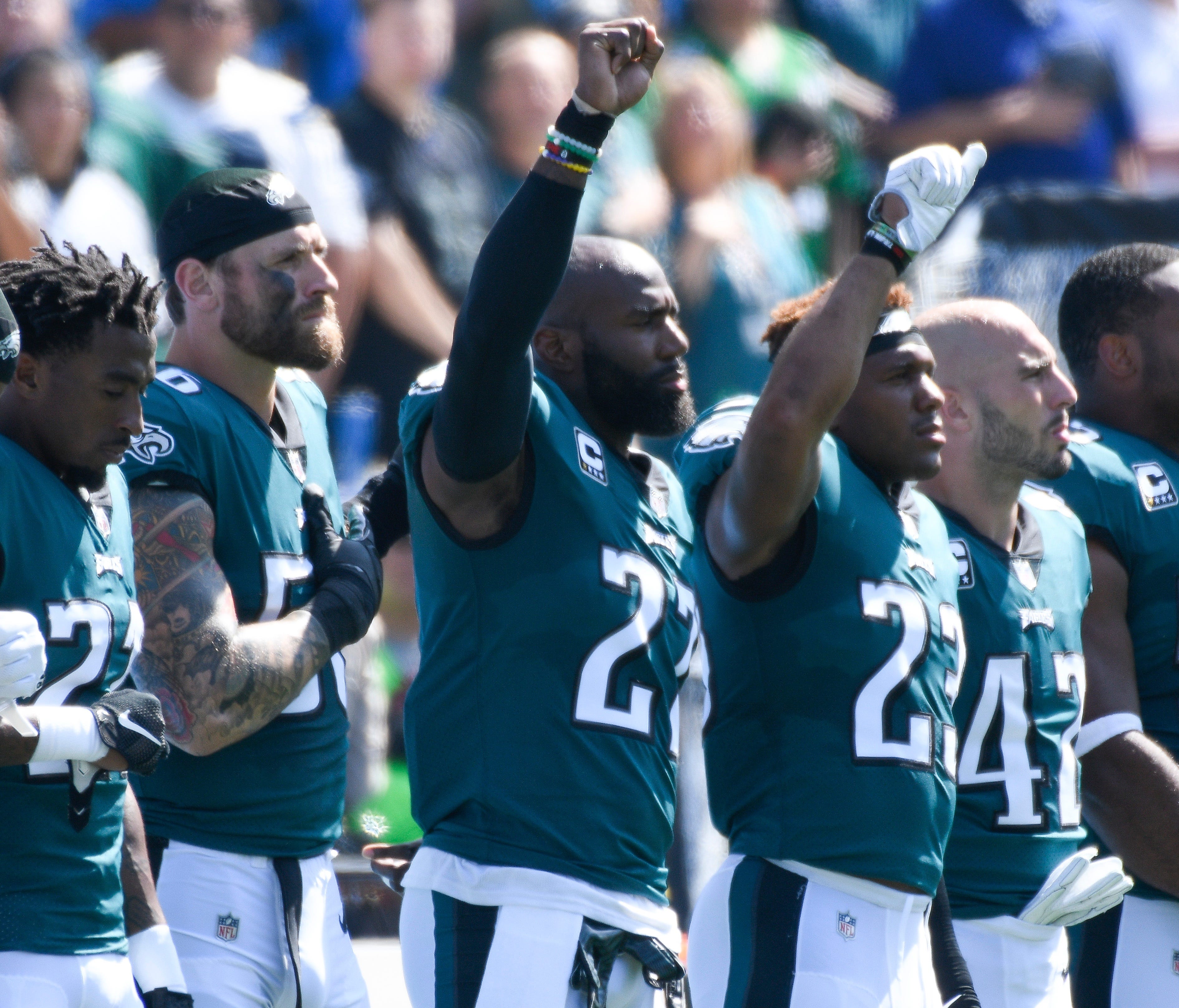 Philadelphia Eagles strong safety Malcolm Jenkins, center, and free safety Rodney McLeod raise a fist in the air during the national anthem before a game against the Chargers in Oct. 2017.