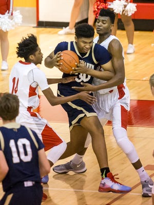 Salesianum's Tariq Ingraham is double teamed by Smyrna's Anthony Watson (No. 14) and Azubuike Nwankwoand in the first half of Smyrna's 53-40 win over Salesianum at Smyrna High School on Tuesday night.