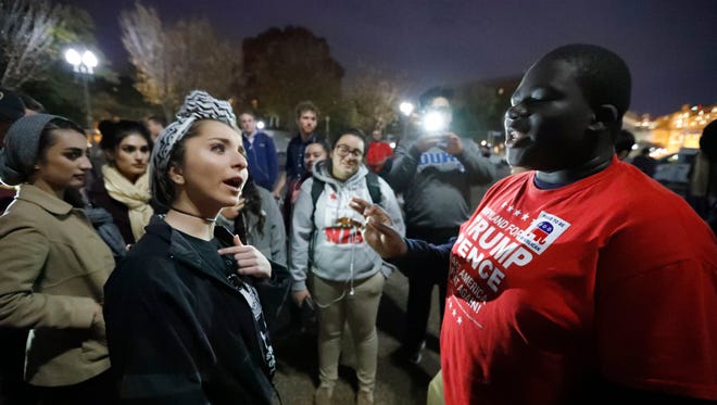 Meriem Palesty, left, from Washington, a Muslim woman of Syrian descent, argues her point with Samuel Tebi, from Gaithersburg, Md., a supporter of President-elect Donald Trump, during an election protest in front of the White House on Nov. 11.
