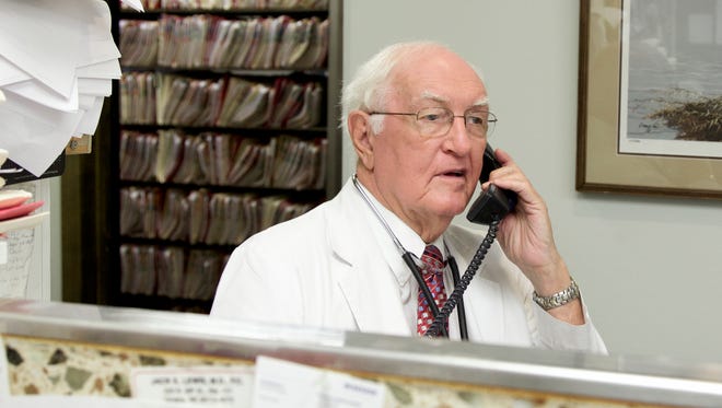 Eighty-year-old practicing physician Dr. Jack Lewis uses a telephone in his office in Omaha, Neb., on Thursday.