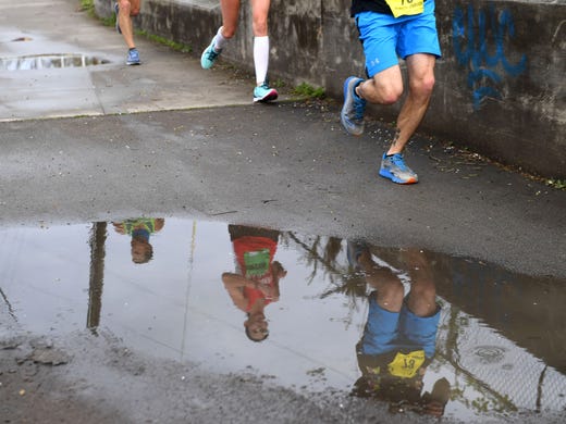 Runners stay away from a puddle along the Third Creek
