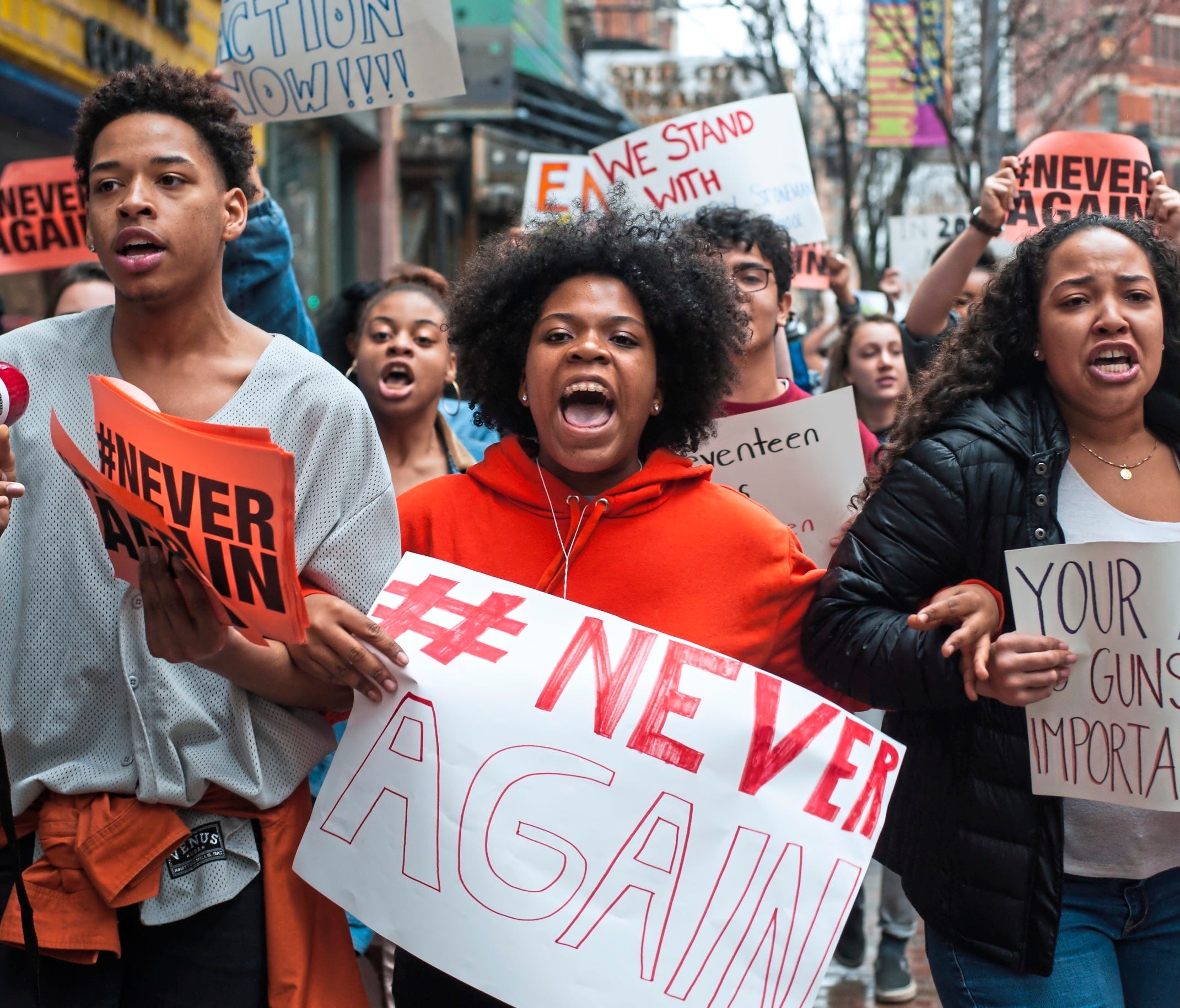 High school students Mia Arrington, center, 18, of West End, and Cheyenne Springette, right, 17, of Mt. Oliver, lead chants as they march down Liberty Avenue during a walk-out in solidarity with other high schools across the country to show support f