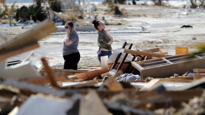 Christina Amanda, right, and Connie Huff, wait for an insurance adjuster as they look for their possessions at the site of their destroyed home in the aftermath of Hurricane Michael in Mexico Beach, Fla., Oct. 17, 2018.