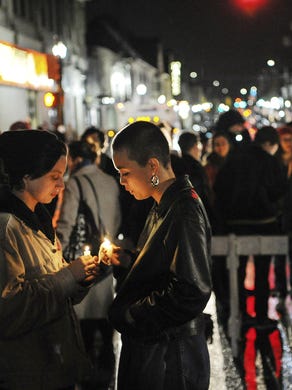 Rosie Villano, left, and Chai Smith, both Carnegie Mellon of Oakland, hold candles during an interfaith vigil outside of Sixth Presbyterian Church, Saturday, Oct, 27, 2018, in the Squirrel Hill section of Pittsburgh. (Alexandra Wimley/Pittsburgh Post-Gazette via AP)