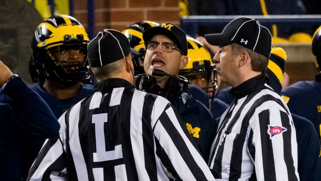 Michigan head coach Jim Harbaugh argues with the officials after the two teams had a scuffle in the third quarter.