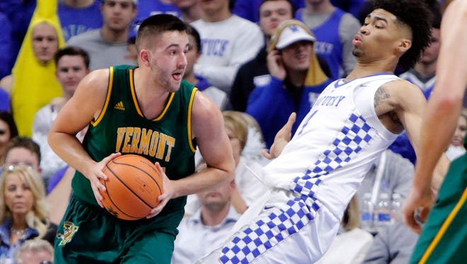 Vermont's Drew Urquhart, left, commits a charging foul against Kentucky's Nick Richards during the first half of an NCAA college basketball game, Sunday, Nov. 12, 2017, in Lexington, Ky. (AP Photo/James Crisp)