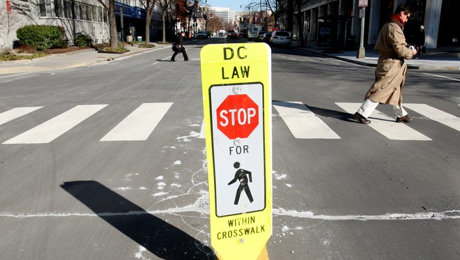 Washington, D.C., has added signs like this one at some intersections to alert drivers to pedestrians.