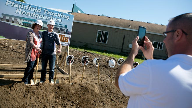 Vice president and co-Owner of Plainfield Trucking Darlene Thurley, left, poses with her son Tomio Sagami, center,  whileEllis Construction's vice president of business development Andrew Halverson, right, takes their photo after the ground breaking ceremony for the new Plainfield Trucking facility, Wednesday, Sept. 9, 2015.