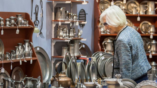 
Audrey Edwards looks at pewter antique dishes at Bette and Melvyn Wolf Inc.'s booth at the Delaware Antiques Show on Sunday.
