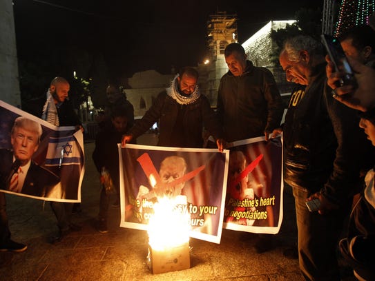 Palestinian protesters burn pictures of President Trump