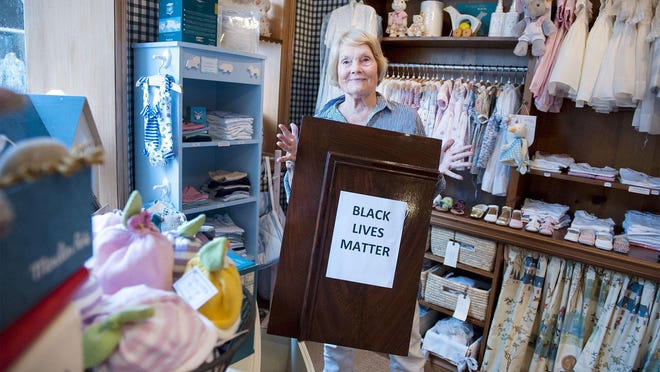 Leta Austin Foster, 80,  was the only person to show up to a demonstration Tuesday in Palm Beach to protest George Floyd's death. Foster, seen here Thursday, is displaying her sign in support of the Black Lives Matter human rights movement in the window of her Leta Austin Foster Boutique in Via Mizner off Worth Avenue.