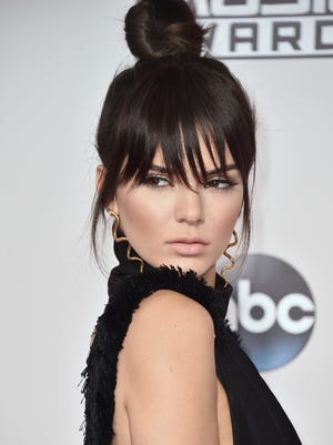 FILE - In this Nov. 22, 2015 file photo, Kendall Jenner arrives at the American Music Awards in Los Angeles. Jenner says she just a `big kid’ at heart and misses childhood times with her little sister Kylie, when they would head outdoors and play in the dirt. Taking me time for the busy Jenner can mean going poolside or hopping on a motorbike, but it usually involves putting down her phone and trying to live in the moment. (Photo by Jordan Strauss/Invision/AP, File)