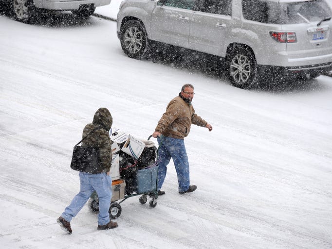 A cart is navigated through snowy Detroit streets Wednesday,