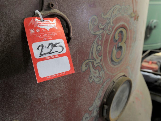 A trolley car with a auction tag waits to be auctioned.