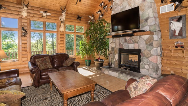A two-story fireplace fits with the log construction in this spacious home at 1461 Barton Ave. SW, Buffalo.