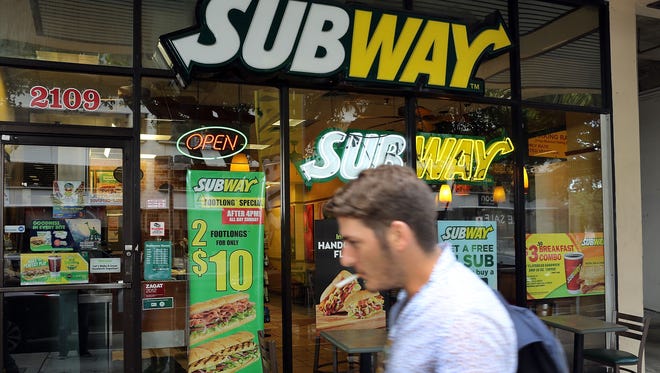 A pedestrian walks past a Subway restaurant in Miami in October. Subway named former Coca Cola executive Joe Tripodi as its new chief marketing officer Thursday, after Tony Pace left the position to start his own company.