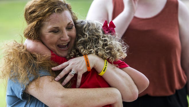 Robyn Young hugs Clara Wade Bolt, 3, an extended family member whom the family has adopted, at a park on Aug. 20, 2017, in Tempe, Arizona. Robyn is wearing tribute bracelets for her son Wade, who was fatally struck by lightning in July 2016 and had a strong bond with Clara. Since Wade's passing, the family said Clara has brought them closer together.