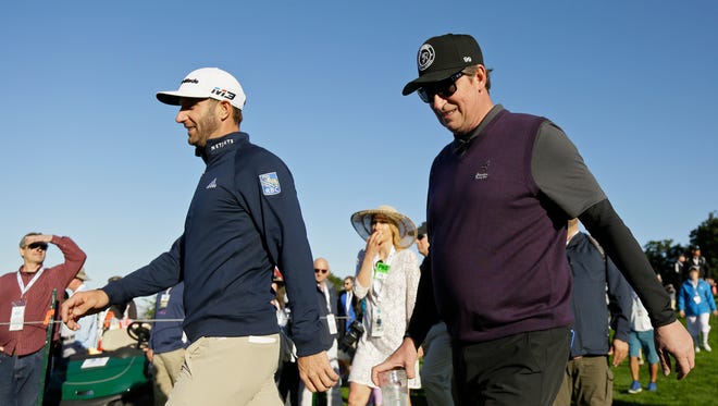 Dustin Johnson, left, and Wayne Gretzky, right, walk to the second tee of the Spyglass Hill Golf Course during the first round of the AT&T Pebble Beach National Pro-Am.