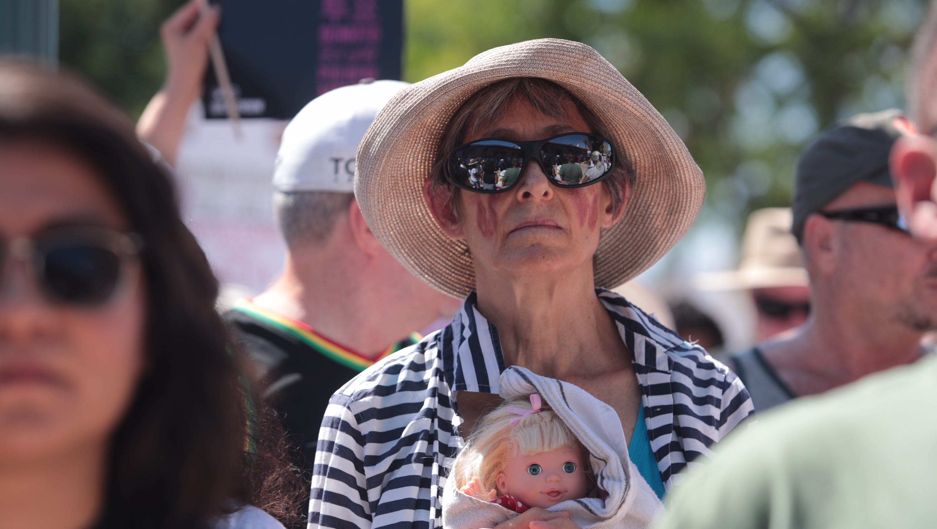 Paula Shutman carries a babydoll during the rally at