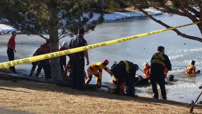 Rescue crews pull a boy from an icy pond in South Reno on Thursday.