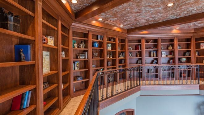 A balcony that hovers over the great room doubles as a library with floor-to-ceiling book shelves.