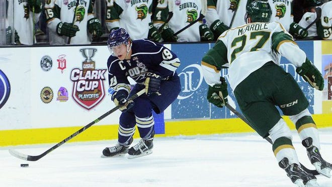 April 19, 2015: Stampede's Logan O'Connor grabs the puck past Sioux City's Matt McArdle in a game at the Denny Sanford Premier Center.