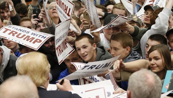 Supporters of Republican presidential candidate, Donald Trump strive to get an autograph during a rally at Radford University in Radford, Va.