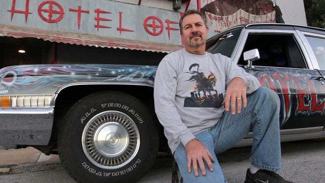 Owner Sterling Mathis is seen here in front of his 1971 customized Cadillac hearse outside the Hotel of Terror on Main Avenue in Springfield on Oct. 15, 2014.