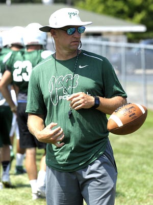 First-year head coach Tom Danosky tosses the football to one of his players.