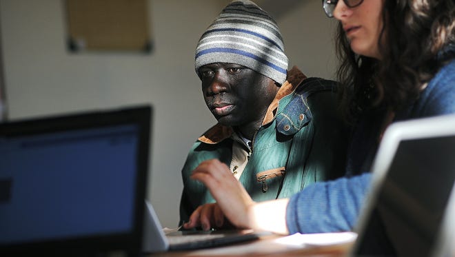 Paul Madut looks on as Tamara Meyerhoff, a job skills program recruiter, helps him with his resume and apply for jobs as part of the Multi-Cultural Center's job skills program Tuesday, Feb. 9, 2016, at the Multi-Cultural Center in downtown Sioux Falls. 