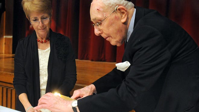 
Eric Straus, 90, of Poughkeepsie, lights one of six candles, all of which represent the six million Jews murdered in the holocaust, during the Community Yom HaShoah Remembrance ceremony Monday at Dutchess Community College in Poughkeepsie. Straus remembers escaping Germany in 1938 as a teenager, watching the synagogue next door to his home being burned to the ground by the Nazis. At left is Paula Reckess, a member of the Community Holocaust Commemoration Committee.
