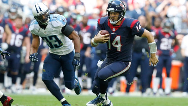 Nov 30, 2014; Houston, TX, USA; Houston Texans quarterback Ryan Fitzpatrick (14) scrambles in the first quarter for a first down against Tennessee Titans safety Michael Griffin (33) at NRG Stadium. Mandatory Credit: Matthew Emmons-USA TODAY Sports