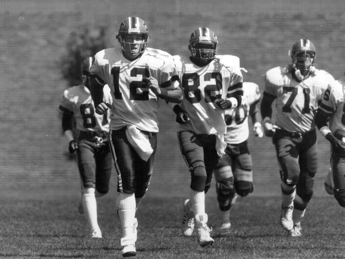 Jim Kelly and other Buffalo Bills run onto the field