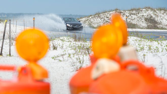 A vehicle makes its way through water as it transitions from the newly rerouted section on Fort Pickens Road in Gulf Islands National Seashore after heavy thunderstorms passed through Pensacola on Monday, April 3, 2017.
