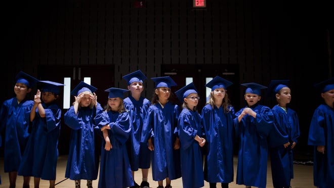 Students line up during kindergarten graduation Wednesday, June 17, 2015 at Landmark Academy.