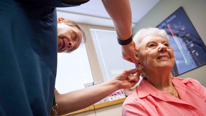 Mary Wilson, 95, gets her hearing aids readjusted by her audiologist Gary Marencin.