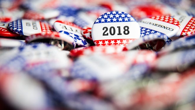 A stock photo showing 2018 campaign buttons.