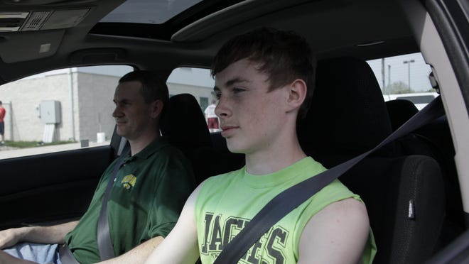 T.J. Stephenson, 14, an eighth-grader at Woodside Middle School in the Saydel district, drives in a school parking lot with his father, Robert Stephenson.