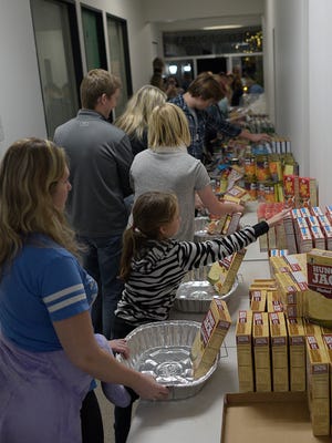 Arianna Bianchi, 9, and her stepmother Andrea Garcia prepare Thanksgiving baskets.   JUNFU HAN | STAFF PHOTOGRAPHER