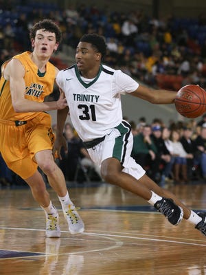 Trinity’s Jay Scrubb (31) drives against St. X’s Tyler Barnes (15) during their game at Broadbent Arena.Jan. 6, 2017