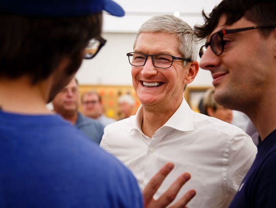 Apple CEO Tim Cook talks with employees on a visit