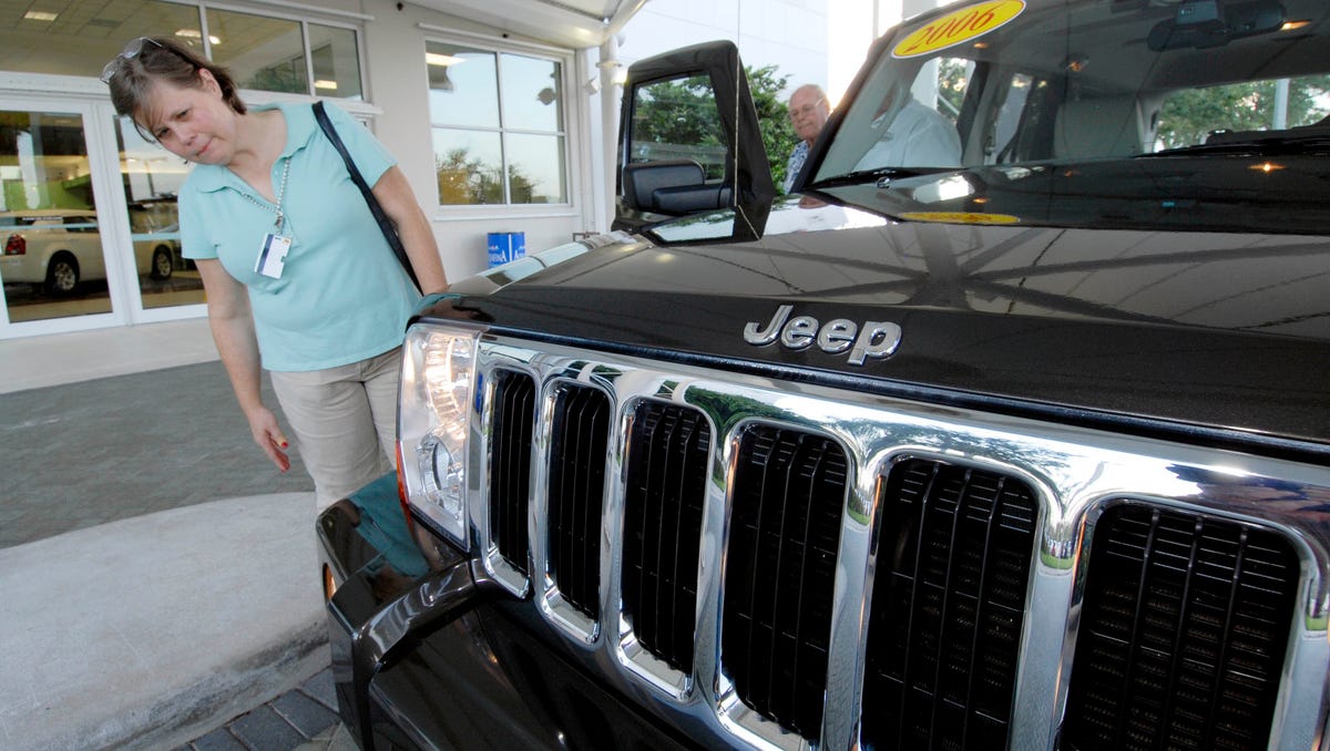 Car buying customer Debbie Bradley leans forward to look at the grille on a 2006 Jeep Commander at Arrigo Dodge-Chrysler-Jeep in West Palm Beach, Florida.